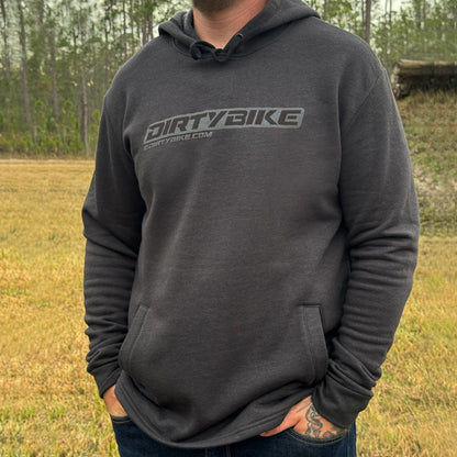 Person wearing a dark gray hoodie with 'DIRTYBIKE' logo outdoors.